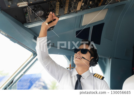 Portrait of a trained airplane captain in uniform preparing to fly in a simulator cockpit. Portrait of a trained airplane captain in uniform preparing to fly in a simulator cockpit. 130056685