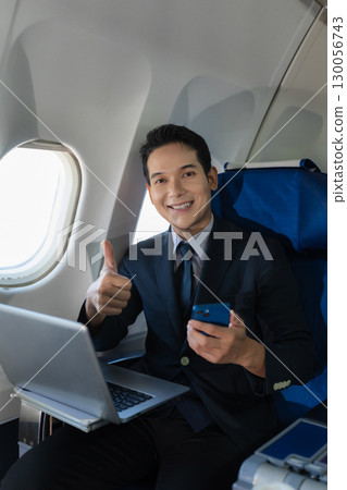 Traveling and technology. young business man working on Laptop and smartphone while sitting in airplane. Traveling and technology. young business man working on Laptop and smartphone while sitting in airplane. 130056743