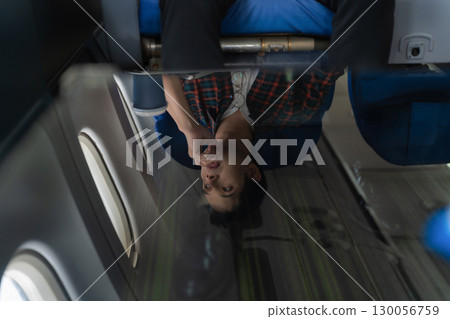 Sad asian male with headache feeling sick while sitting in the airplane , Passengers near the window. 130056759
