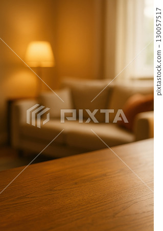 Wooden table surface in softly lit cozy living room with blurred background warm home interior concept Wooden table surface in softly lit cozy living room with blurred background warm home interior concept 130057517