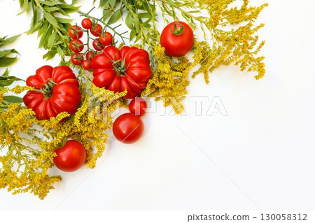 Red fresh heirloom, oxheart, cherry tomatoe. Canadian goldenrod, solidago flowers isolated on white table background. Organic food, healthy eating. Gardening banner. Copy space. Flat lay, top view Red fresh heirloom, oxheart, cherry tomatoe. Canadian goldenrod, solidago flowers isolated on white table background. Organic food, healthy eating. Gardening banner. Copy space. Flat lay, top view 130058312