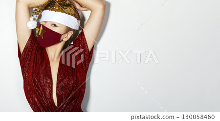 Woman with red christmas hat, black medical mask. Fashion shiny style for xmas time. Protection from flu on holidays 130058460