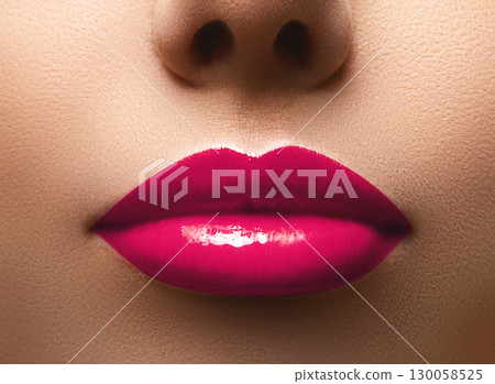 Closeup shot of beautiful full lips with magenta glossy make-up. Perfect bright pink lipstick. Plastic surgery Closeup shot of beautiful full lips with magenta glossy make-up. Perfect bright pink lipstick. Plastic surgery 130058525