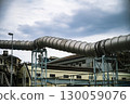 一條巨大的銀色管道穿過工業區 130059076