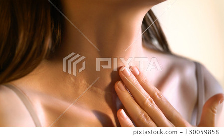 Close-up of an unrecognizable woman touching her neck. Endocrine health prevention. Diseases of the thyroid gland. Cancer screening. Endocrinology. Concept of medicine and health care. Self care Close-up of an unrecognizable woman touching her neck. Endocrine health prevention. Diseases of the thyroid gland. Cancer screening. Endocrinology. Concept of medicine and health care. Self care 130059858
