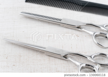 Close-up of a set of haircutting scissors, thinning shears and a comb 130060118