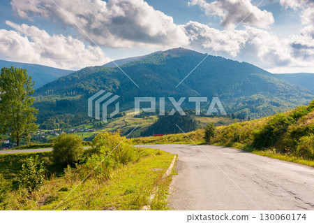 mountain pass on a sunny evening. road winding down the hill. scenery with valley of volovets in front of temnatyk peak under cloudy sky mountain pass on a sunny evening. road winding down the hill. scenery with valley of volovets in front of temnatyk peak under cloudy sky 130060174