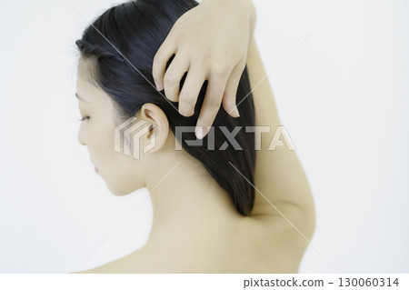 Young woman showing nape with hand in hair against white background Young woman showing nape with hand in hair against white background 130060314