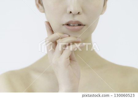 Facial part cut of a young woman holding her hand on her cheek on a white background 130060523