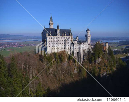 Majestic Neuschwanstein Castle stands proudly on a mountain top in Bavaria, showcasing stunning architecture against a clear blue sky 130060541