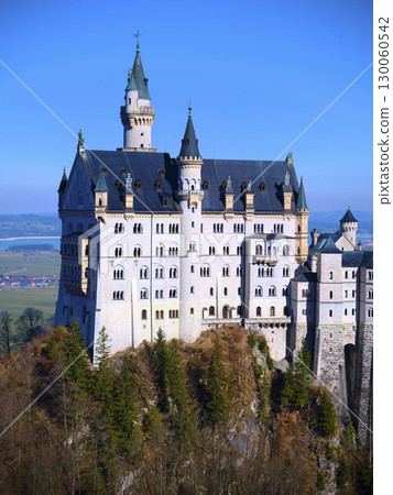 Majestic Neuschwanstein Castle perched on a mountain against a clear blue sky in Bavaria, Germany Majestic Neuschwanstein Castle perched on a mountain against a clear blue sky in Bavaria, Germany 130060542