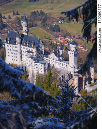 Unique view of a fairy tale castle surrounded by snow-capped trees in the Bavarian countryside on a clear day 130060577