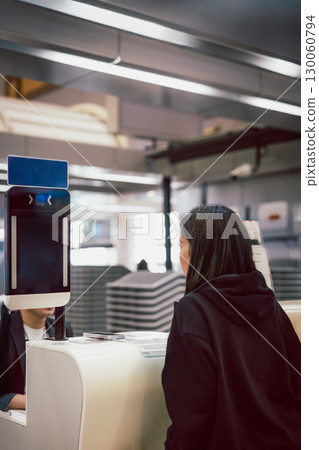 Asian woman using face scanner at the airport. 130060794