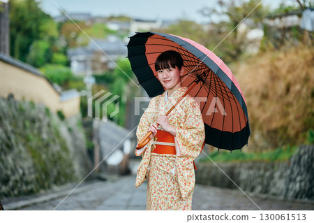 一位穿著和服、撐著日本傘散步的女子 130061513