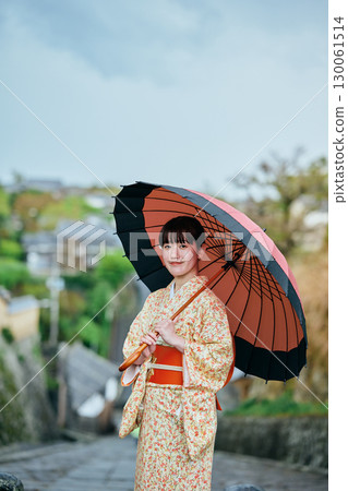 一位穿著和服、撐著日本傘散步的女子 130061514