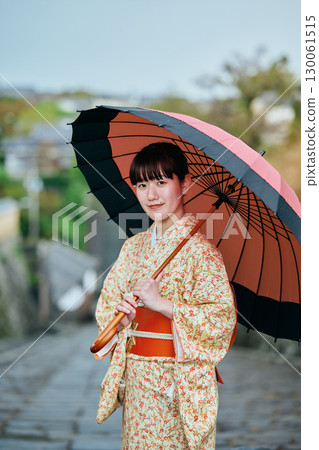 一位穿著和服、撐著日本傘散步的女子 130061515