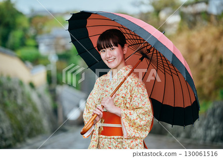 一位穿著和服、撐著日本傘散步的女子 130061516