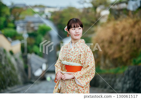 A woman in a kimono strolling through the castle town 130061517