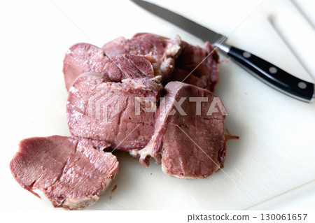 Sliced boiled beef tongue on white cutting board 130061657