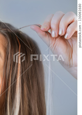 Salon hair extension procedure with each strand carefully prepared by professional hairstylist for perfect results 130061680