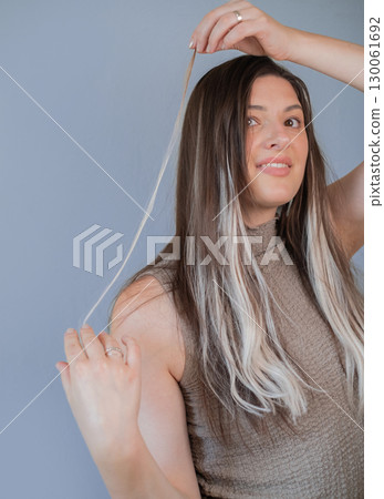 Hair extensions in beauty salon attention to each strand and capsule professional hairstylist at work 130061692