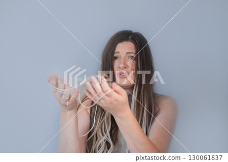 Sad young woman holding hairbrush with fallen strands worried about hair breakage and hair loss problem Sad young woman holding hairbrush with fallen strands worried about hair breakage and hair loss problem 130061837