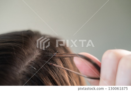 Woman with long hair extensions showing smooth strands and salon care after professional beauty treatment 130061875