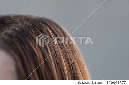 Professional hair extension process with thin capsules hair care treatment in a beauty salon by skilled hairstylist 130061877