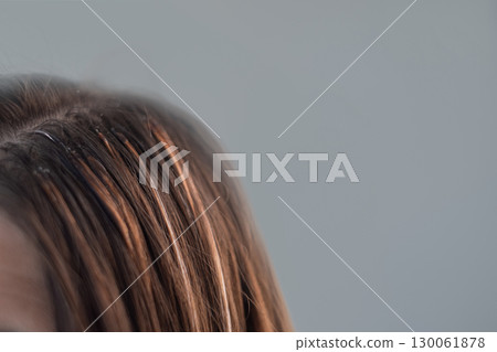 Young woman with hair extensions showing the result of a professional hairstylist work in a modern beauty salon Young woman with hair extensions showing the result of a professional hairstylist work in a modern beauty salon 130061878