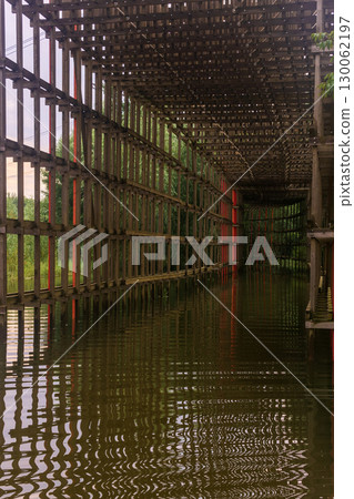 wooden gallery above the bike path in the park flooded after heavy rain 130062197