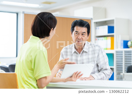 Senior man consulting with care manager 130062212
