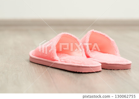 Pink home shoes on the floor. Slippers of pink colour in the room Pink home shoes on the floor. Slippers of pink colour in the room 130062755
