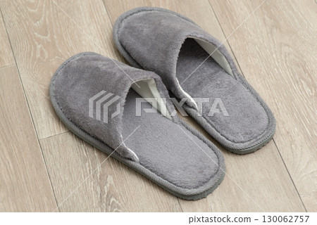 Top down shot of gray slippers on the floor. Wearing slippers at home concept Top down shot of gray slippers on the floor. Wearing slippers at home concept 130062757