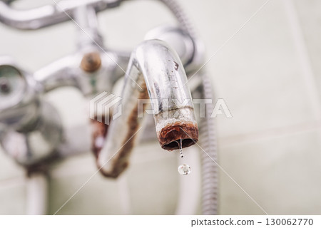 Old bathroom faucet with water drop. Tap covered in rust, lime layer, toned photo 130062770