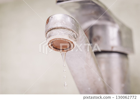 Water dripping from old tap. Dirty faucet in bathroom, warm toned photo Water dripping from old tap. Dirty faucet in bathroom, warm toned photo 130062772