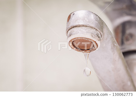 Close up of water dripping from dirty tap all in calcium and rust. Problems with water, hard water concept, warm toned photo Close up of water dripping from dirty tap all in calcium and rust. Problems with water, hard water concept, warm toned photo 130062773