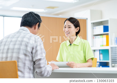 Care staff at the reception desk of a senior man Care staff at the reception desk of a senior man 130063103