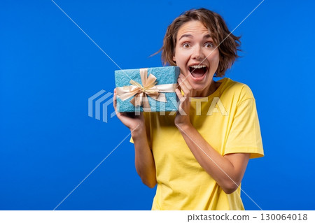 Happy Woman Gift Box On Blue Background. Young amazed Girl Smiling, got present 130064018