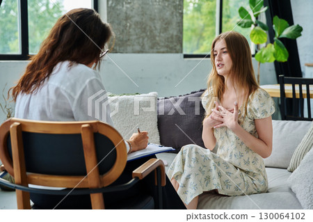 Young woman at therapy session with female psychologist, social worker Young woman at therapy session with female psychologist, social worker 130064102