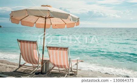 Scenic tropical beach with two colorful striped deck chairs under a large parasol Scenic tropical beach with two colorful striped deck chairs under a large parasol 130064373