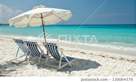 Scenic tropical beach with two colorful striped deck chairs under a large parasol Scenic tropical beach with two colorful striped deck chairs under a large parasol 130064379