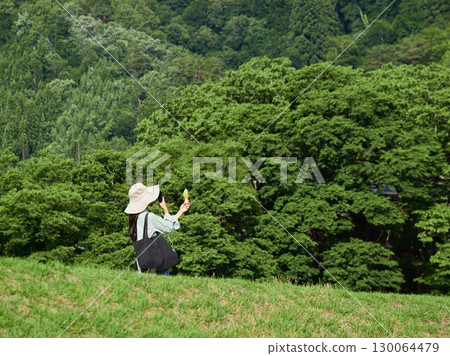 Tourists strolling along the Shogawa River in Shirakawa-go, a popular tourist spot 130064479