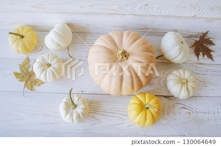 Autumn harvest of assorted pumpkins. Still life with pumpkins and autumn leaves on wooden surface. Autumn harvest of assorted pumpkins. Still life with pumpkins and autumn leaves on wooden surface. 130064649
