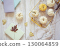 Autumn harvest of assorted pumpkins. Still life with pumpkins and autumn leaves on wooden surface. 130064859