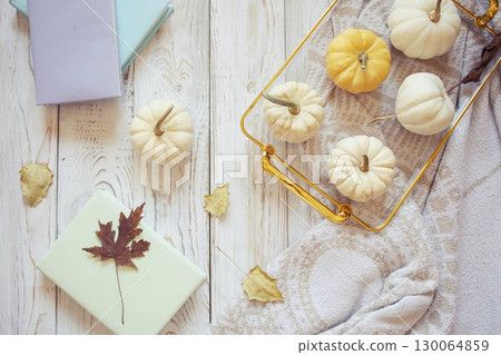 Autumn harvest of assorted pumpkins. Still life with pumpkins and autumn leaves on wooden surface. 130064859