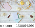 Autumn harvest of assorted pumpkins. Still life with pumpkins and autumn leaves on wooden surface. 130064860