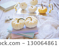 Autumn harvest of assorted pumpkins. Still life with pumpkins and autumn leaves on wooden surface. 130064861