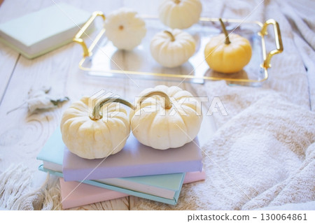 Autumn harvest of assorted pumpkins. Still life with pumpkins and autumn leaves on wooden surface. 130064861