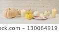 Cozy autumn still life with coffee, wool blanket, pumpkins, candles and books. Seasonal still life. 130064919