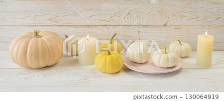 Cozy autumn still life with coffee, wool blanket, pumpkins, candles and books. Seasonal still life. 130064919